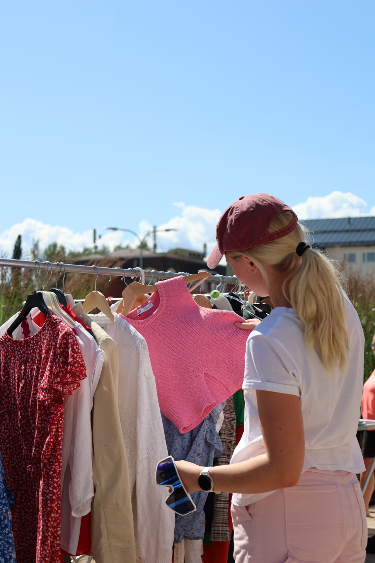 Mora Köpstad – kläder på klädställning i sommarsol